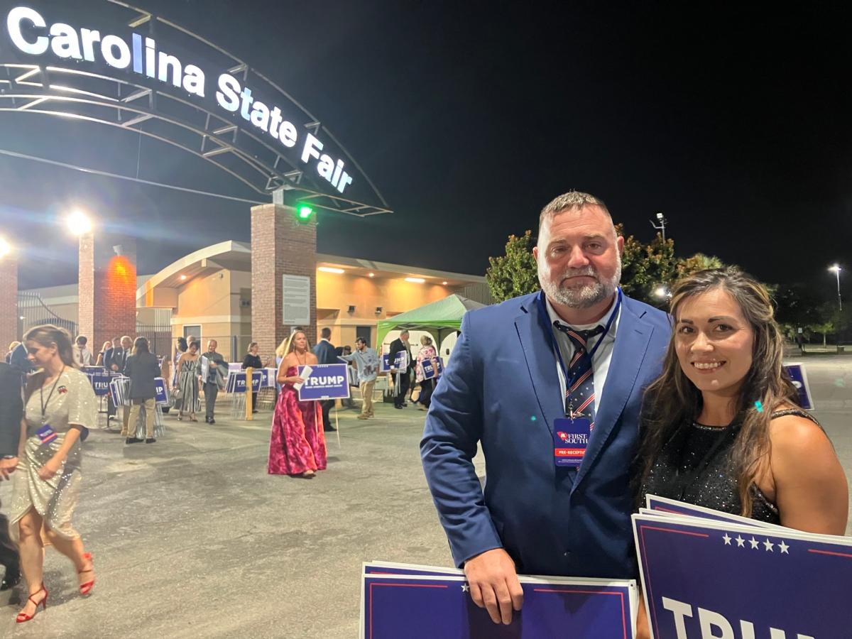 Travis Grimsley, 44, and wife, Malary, 36, pick up yard signs promoting the 2024 candidacy of former President Donald Trump, following his speech at the South Carolina State Fairgrounds in Columbia, S.C., on Aug. 5, 2023. (Janice Hisle/The Epoch Times)