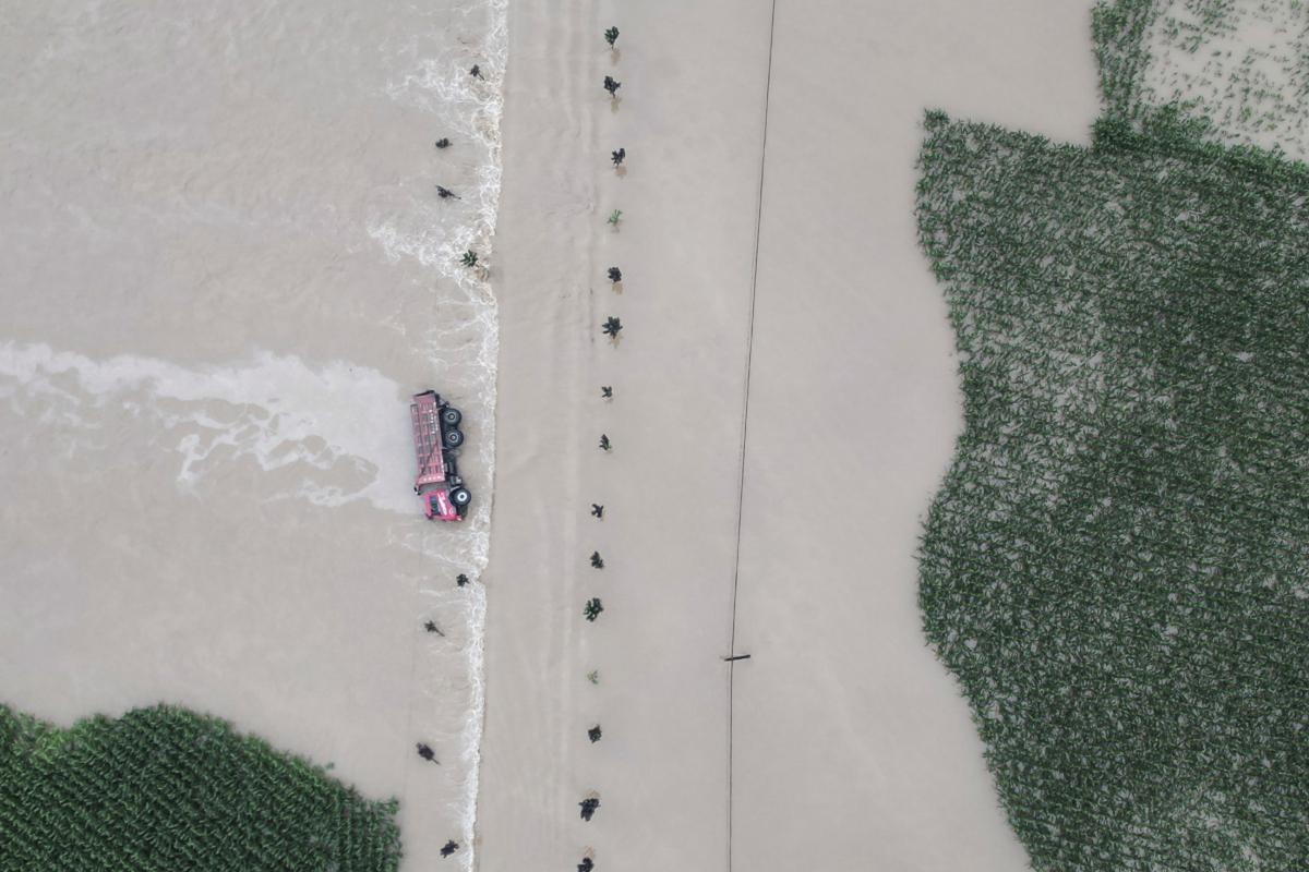 A truck turned on its side is seen as flood waters flowing across roads and fields in Kaiyuan Town of Shulan in northeastern China's Jilin Province on Aug. 4, 2023. (Yan Linyun/Xinhua via AP)