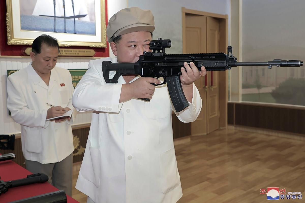 In this undated photo provided by the North Korean regime, North Korean leader Kim Jong Un (R) holds a weapon during his three-day inspection from Aug. 3 until Aug. 5, 2023 at major munitions factories in North Korea. (Korean Central News Agency/Korea News Service via AP)