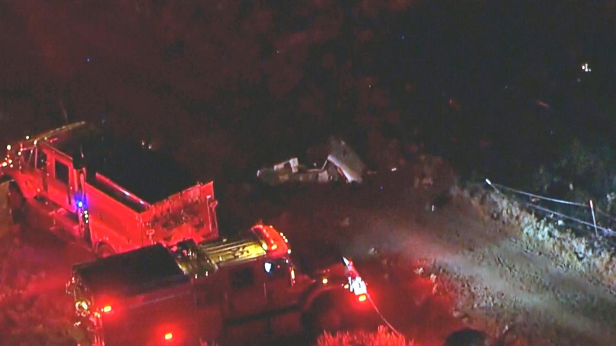 This aerial image taken from video provided by ABC7 Los Angeles shows the scene of a firefighting helicopter crash, with emergency vehicles at the base of a mountain and the area blocked off with police tape, in Cabazon, Calif., on Aug. 6, 2023. (ABC7 Los Angeles via AP)