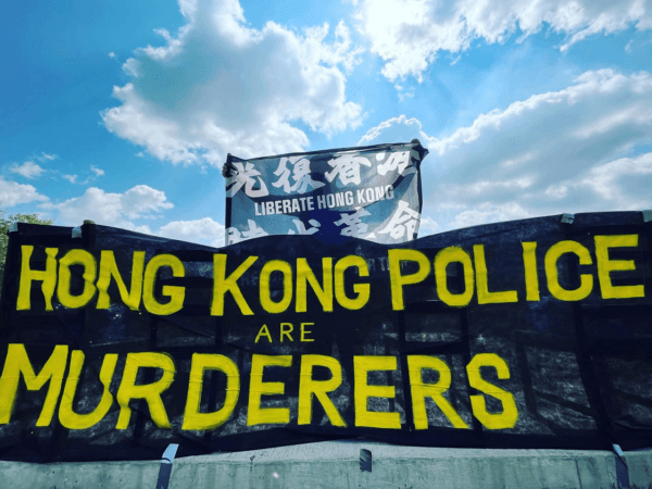 Banners held by demonstrators gathered outside the Forks National Historic Site in Winnipeg on Aug. 6, 2023, to protest the participation of the Hong Kong Police Force in the World Police and Fire Games. (Courtesy of Winnipeg Hong Kong Concern)