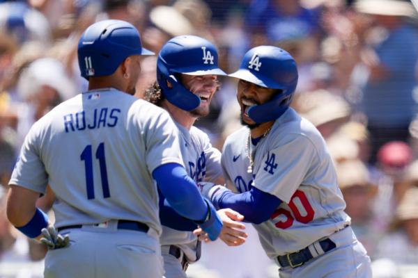 Los Angeles Dodgers' Mookie Betts, right, celebrates with teammates James Outman, center, and Miguel Rojas (11) after hitting a grand slam during the fourth inning of a baseball game against the San Diego Padres in San Diego on Aug. 7, 2023. (AP Photo/Gregory Bull)