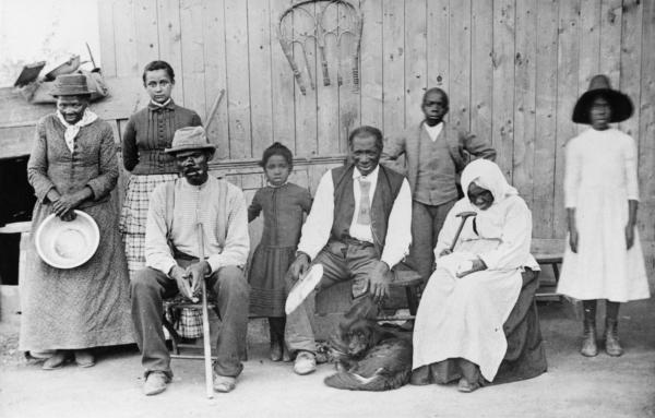 Harriet Tubman (L) poses with family and friends on her porch in Auburn, N.Y., in the 1880s. Ms. Tubman helped people escape slavery via the Underground Railroad, which terminated in Canada. (MPI/Getty Images)
