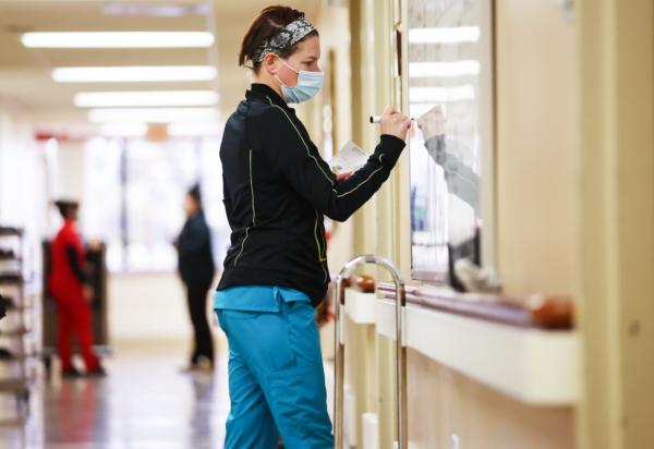A monitor technician makes notes on the assignment board in a unit that once held numerous COVID-19 patients at Providence St. Mary Medical Center in Apple Valley, Calif., on March 11, 2022. (Mario Tama/Getty Images)