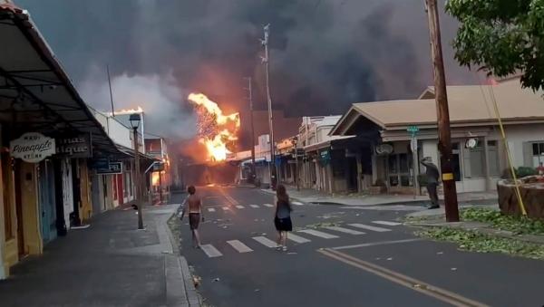 People watch as smoke and flames fill the air from raging wildfires on Front Street in downtown Lahaina, Maui, on Aug. 8, 2023. (Alan Dickar via AP)