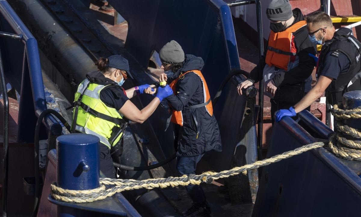Border Force officials guide a pregnant lady ahead of other newly arrived illegal immigrants to a holding facility after being picked up in a dinghy in the English Channel in Dover, England, on June 9, 2021. (Dan Kitwood/Getty Images)