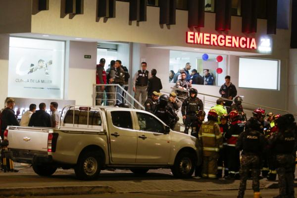 A bullet-riddled vehicle is surrounded by police as they guard the hospital where several of the injured were taken after the attack on presidential candidate Fernando Villavicencio, who was shot to death in Quito, Ecuador, on Aug. 9, 2023. (AP Photo/Juan Diego Montenegro)