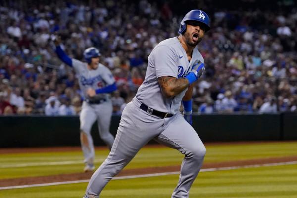 Los Angeles Dodgers' David Peralta (6) yells towards his dugout as he runs out his two RBI single scoring Fredie Freeman (5) against the Arizona Diamondbacks during the eighth inning of a baseball game in Phoenix on Aug. 9, 2023. (Matt York/AP Photo)