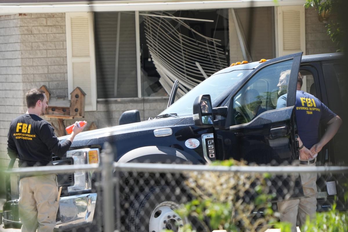 With a broken window in the background, FBI agents process the home of Craig Robertson in Provo, Utah on Aug. 9, 2023. (George Frey/Getty Images)