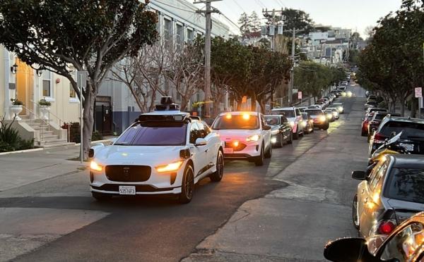 A Waymo driverless taxi stops on a street in San Francisco for several minutes because the back door wasn't completely shut, while traffic backs up behind it, on Feb. 15, 2023. (Terry Chea/AP Photo)