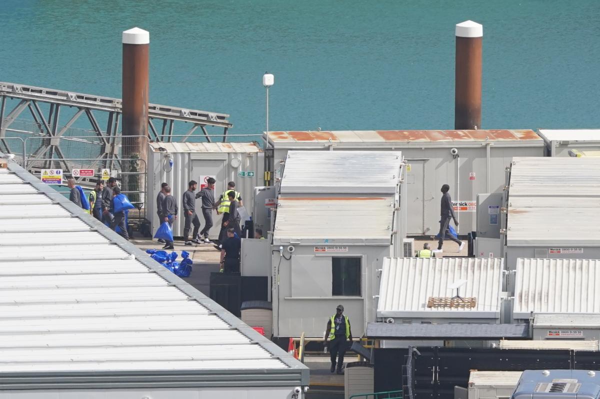 A group of people thought to be illegal immigrants are brought in to Dover, Kent, England, hours after six people are confirmed to have died when a people-smuggling boat sank in the Channel on Aug. 12, 2023. (Stefan Rousseau/PA)