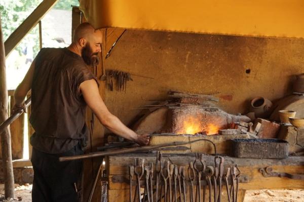 A blacksmith keeps the forge fire going. (Courtesy of Guédelon)