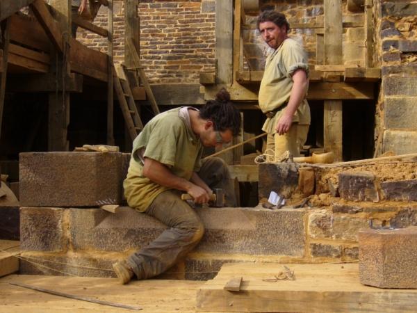 Stonemasons setting stone in a structure. (Courtesy of Guédelon)