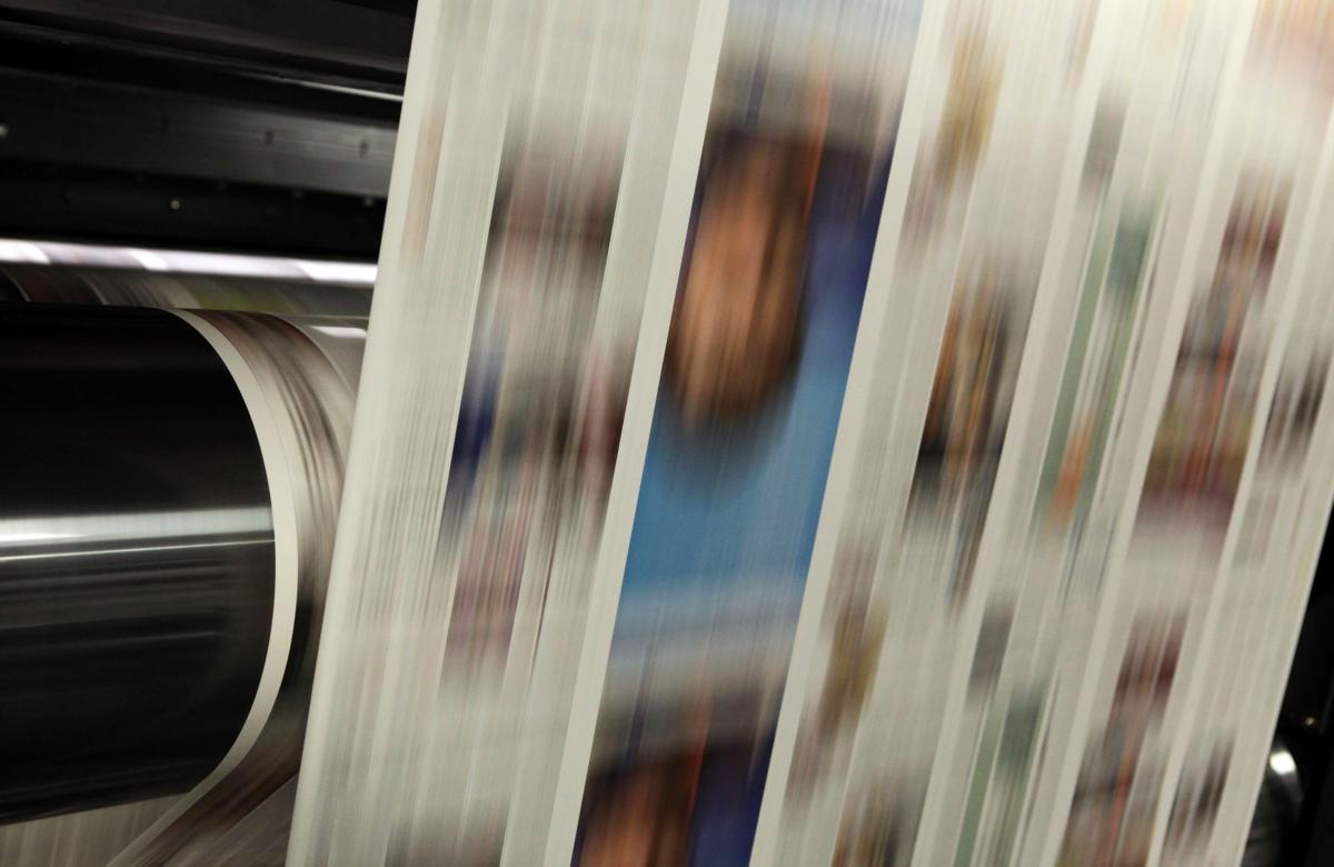 Freshly printed copies of the new glossy San Francisco Chronicle move through a printing press in Fremont, Calif., on Nov. 8, 2009. (Justin Sullivan/Getty Images)