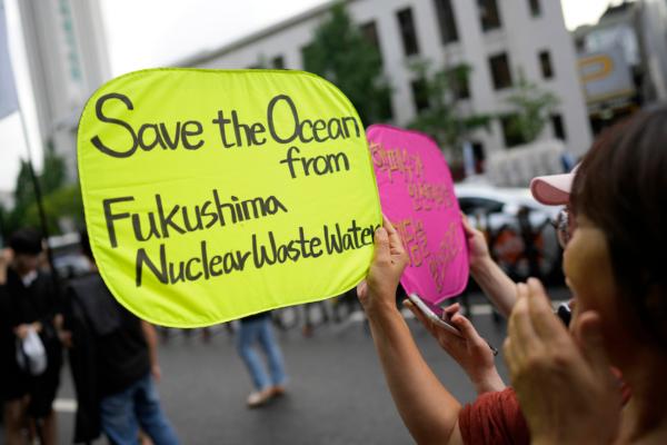 A member of a civic group holds a sign in a rally to oppose the Japanese government's plan to release treated radioactive water into the sea from the damaged Fukushima nuclear power plant, in Seoul, South Korea, on Aug. 12, 2023. (AP Photo/Lee Jin-man)