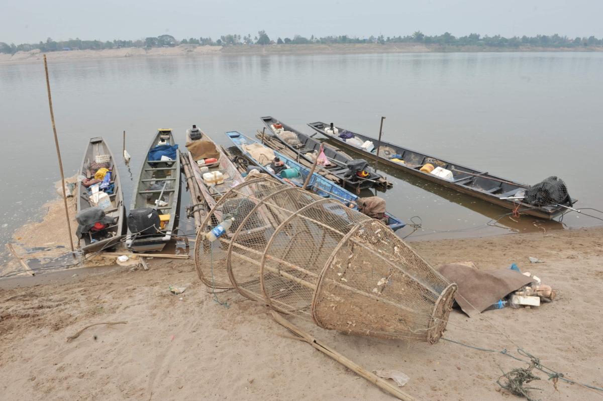 A bamboo fishing trap lies on the bank of the drought-hit Mekong River next to fishing boats at Thatkhao village, in the vicinity of Vientiane, Laos, on March 27, 2010. (Hong Dinh Nam/AFP via Getty Images)