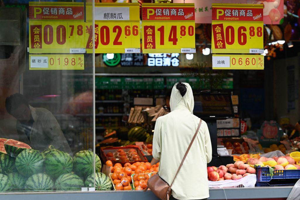 A customer shops for fruits and vegetables at a market in Beijing on Aug. 9, 2023. (Pedro Pardo/AFP via Getty Images)