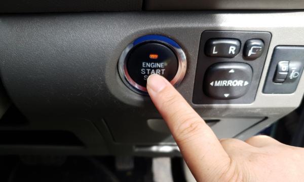 A finger on the ignition of a car which uses a keyless fob. (Lily Zhou/The Epoch Times)