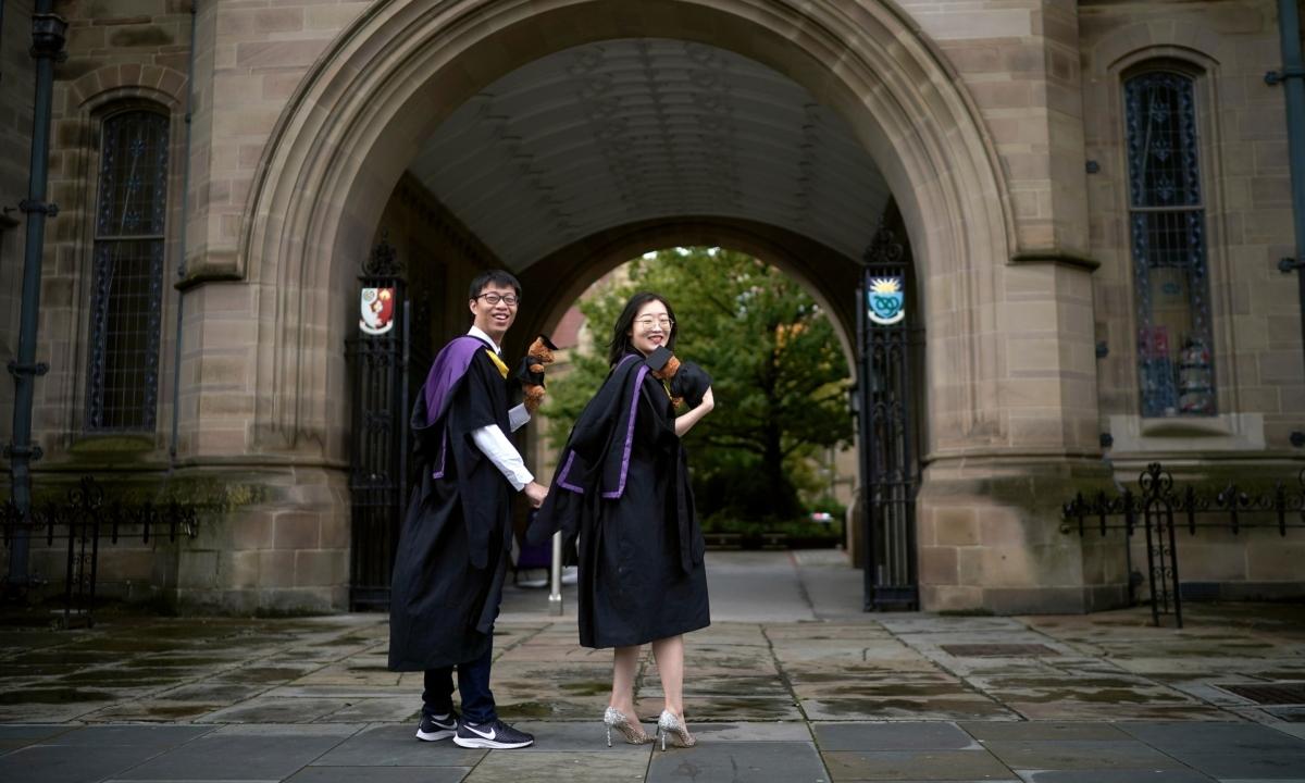 Chinese students stage their December graduation photographs early as they prepare to fly home in Manchester, England, on Oct. 7, 2020. (Christopher Furlong/Getty Images)