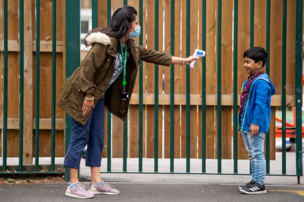A child has his temperature checked by a teacher before entering Earlham Primary School, in London, on June 10, 2020. (Justin Setterfield/Getty Images)