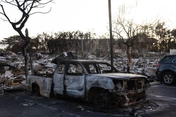 A burnt-out car lies in the driveway of a charred apartment complex in the aftermath of a wildfire in Lahaina, western Maui, Hawaii, on Aug. 12, 2023.(Yuki Iwamura/AFP via Getty Images)