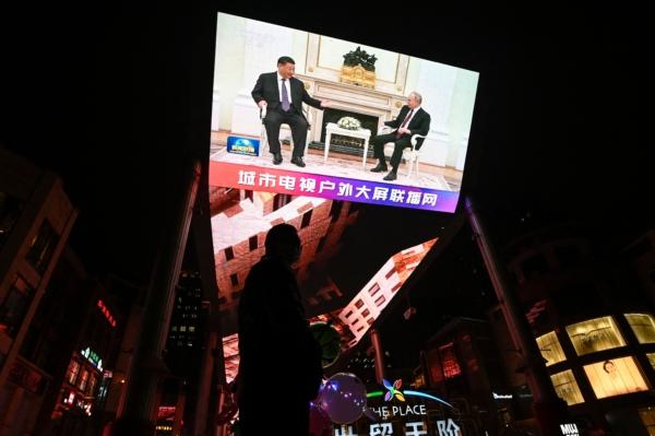 An outdoor screen shows live news coverage of China's leader Xi Jinping meeting with Russian President Vladimir Putin during a state visit in Moscow, along a street in Beijing on March 21, 2023. (Jade Gao /AFP via Getty Images)
