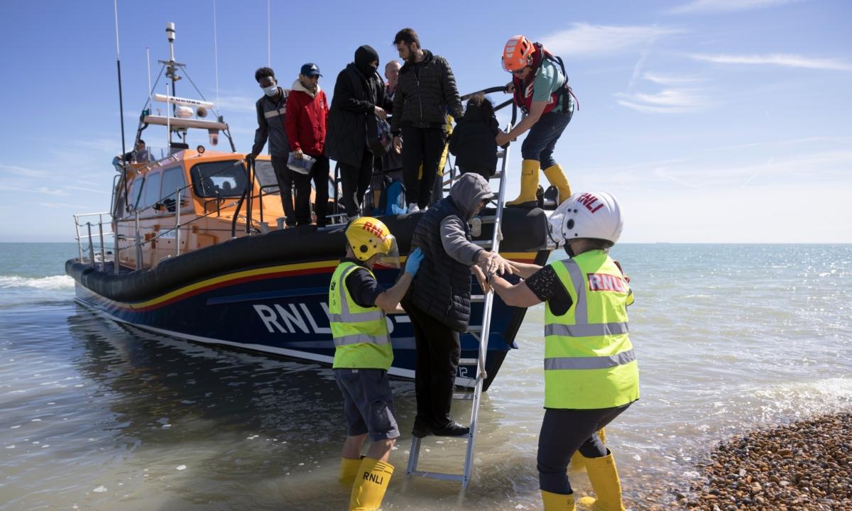 Families are helped ashore by the RNLI after being rescued in the English Channel by the RNLI in Dungeness, England, on August 16, 2023. (Dan Kitwood/Getty Images)