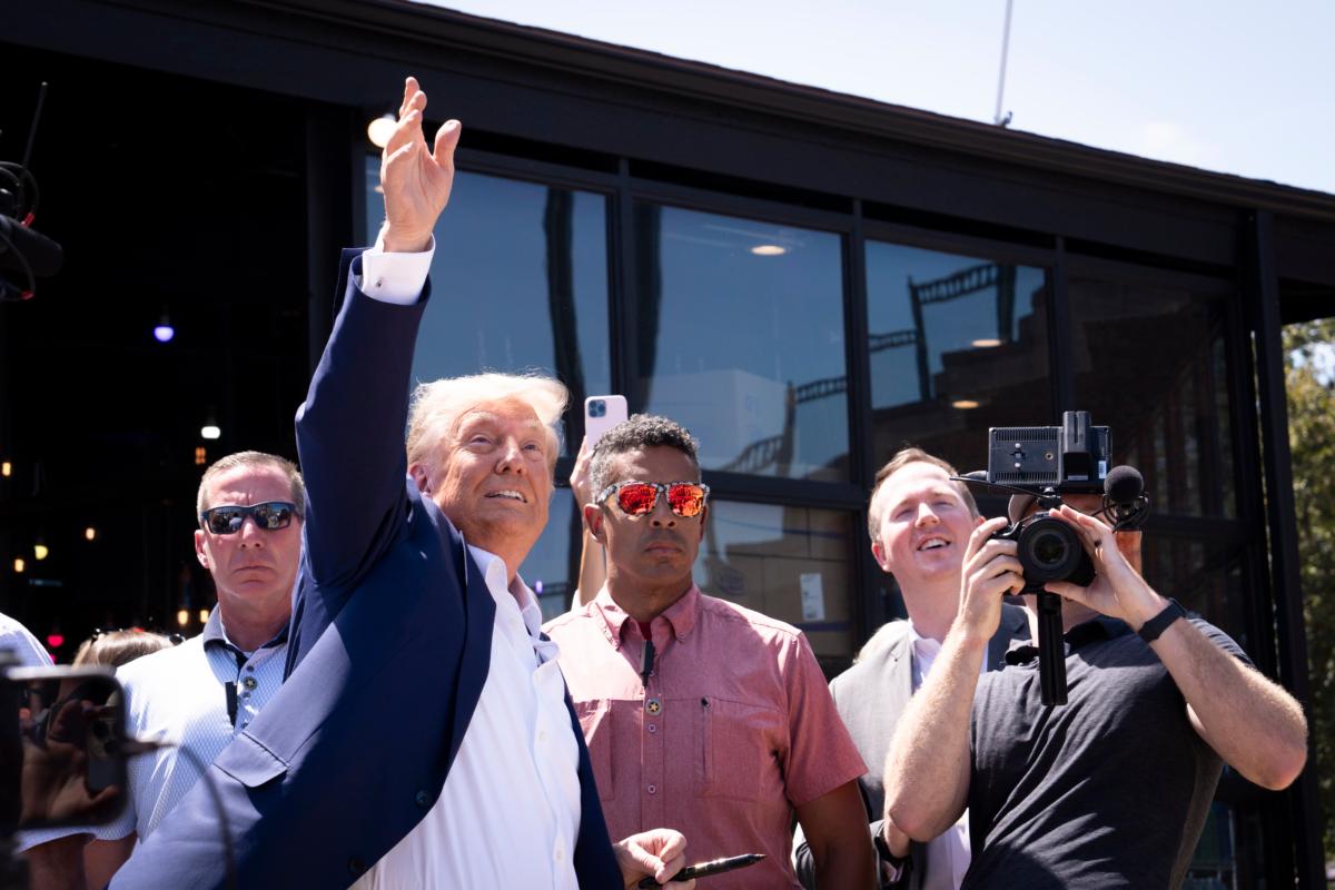 Former President Donald Trump tosses caps to the crowd at the Iowa State Fair in Des Moines, Iowa, on Aug. 12, 2023. (Madalina Vasiliu/The Epoch Times)