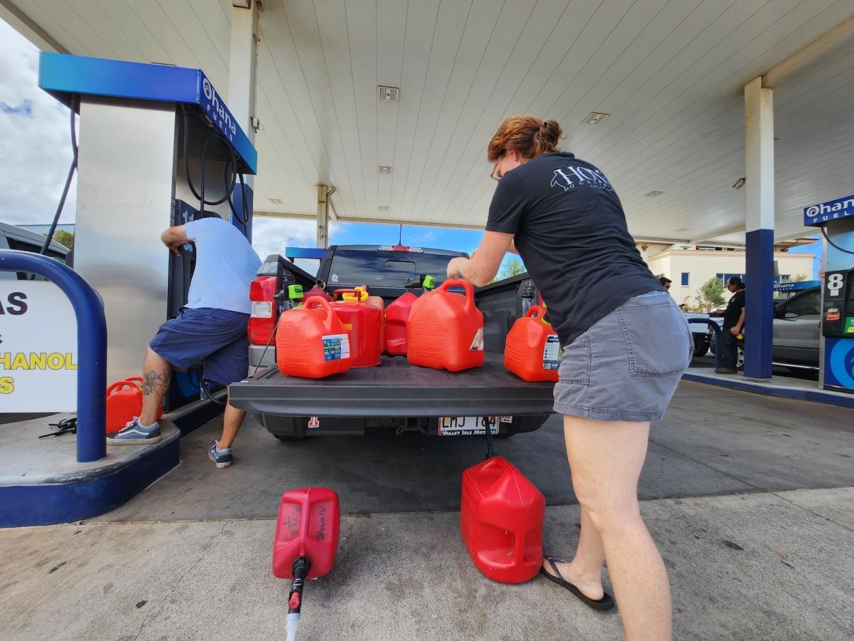 Sarah Turner of West Maui loads containers filled with gasoline in Lahaina Town on Aug. 16, 2023. (Allan Stein/The Epoch Times)