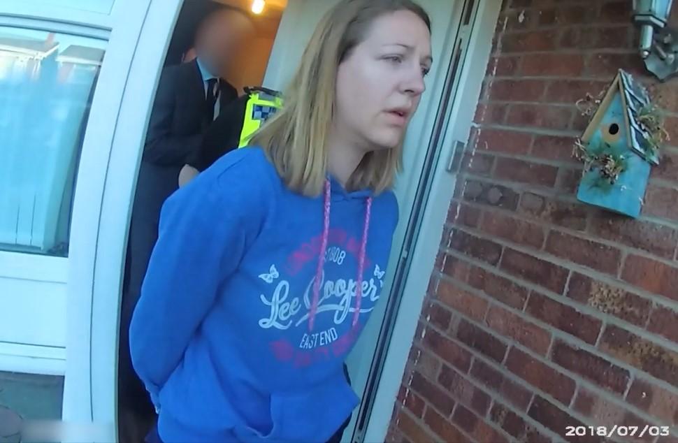Lucy Letby is led away in handcuffs by police after being arrested at her home in Chester, England, on July 3, 2018. (Cheshire Police)