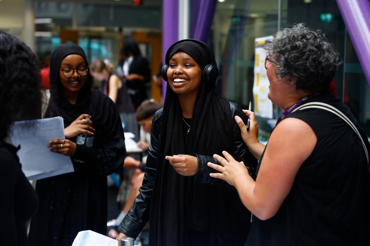 Student Rayaan Mahamoud celebrates her A-level results with a member of teaching staff at City of London Academy in London on Aug. 17, 2023. (Peter Nicholls/Getty Images)