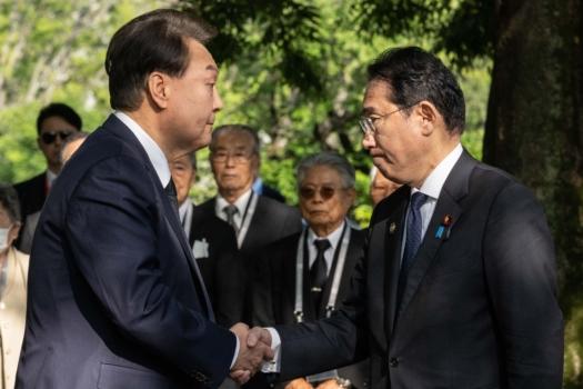 South Korea's Yoon Suk Yeol (L) and Japan's Prime Minister Fumio Kishida shake hands during a visit to the "Monument in Memory of the Korean Victims of the A-bomb" near the Peace Park Memorial during the G7 Summit Leaders' Meeting in Hiroshima, Japan, on May 21, 2023. (Yuichi Yamazaki - Pool / Getty Images)