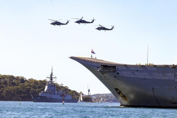 Choppers fly overhead as the HMAS Brisbane (L) enters Sydney Harbour in Sydney, Australia on Aug. 11, 2023 as part of Exercise Malabar annual drill. (AAP Image/Jenny Evans)