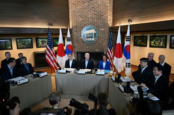 President Joe Biden (C) flanked by Secretary of State Antony Blinken (center left) and Secretary of Commerce Gina Raimondo (center right), speaks during a Trilateral Summit with Japanese Prime Minister Fumio Kishida (2R), and South Korean President Yoon Suk Yeol (2L) at Camp David, Md., on Aug. 18, 2023. (Jim Watson/AFP via Getty Images)