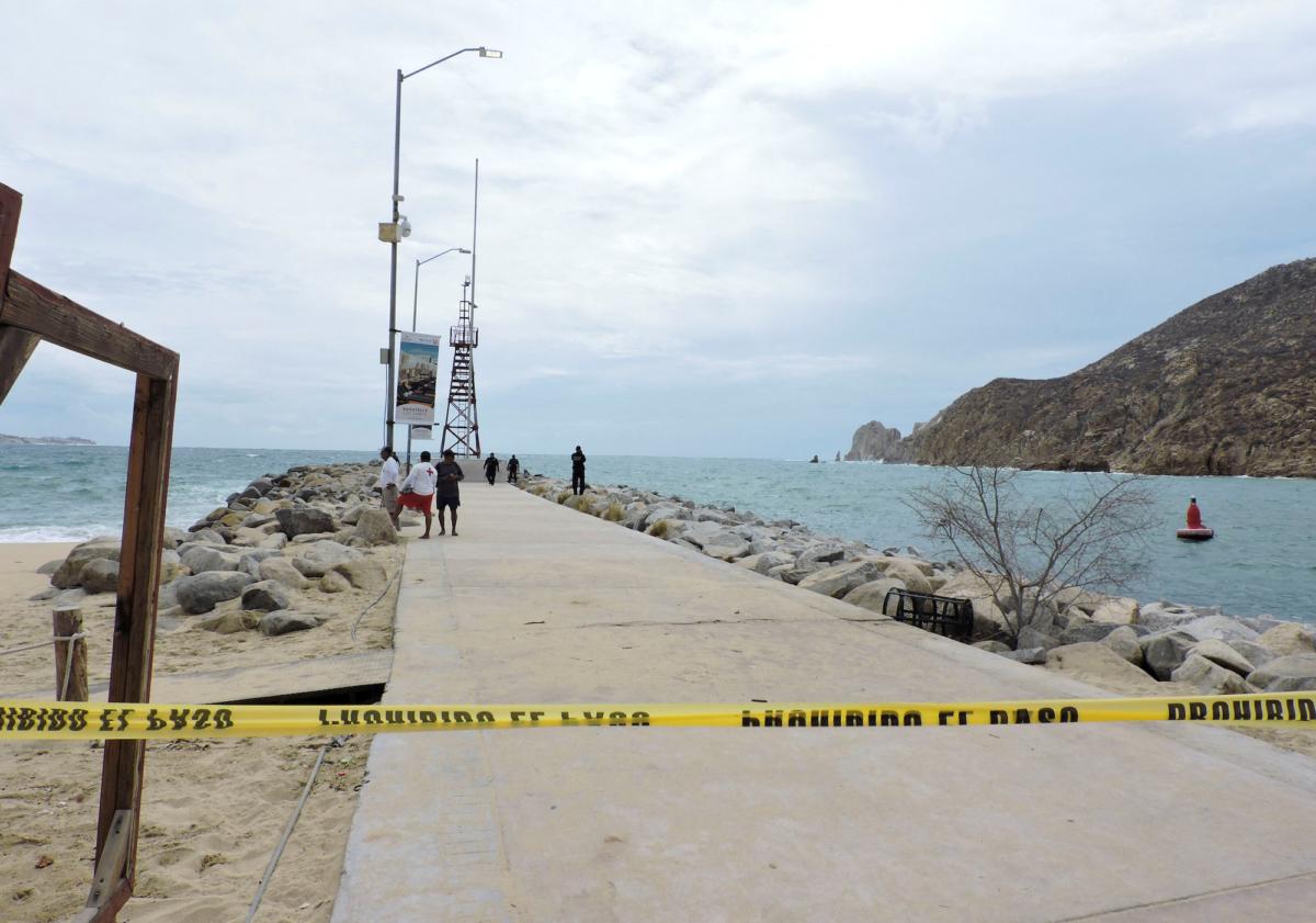 Police officers and lifesavers stand at a breakwater that was closed as a security measure by local authorities while Hurricane Hilary rushes toward Mexico's Baja California peninsula, in Cabo San Lucas, Mexico, on Aug. 18, 2023. (Monserrat Zavala/Reuters)