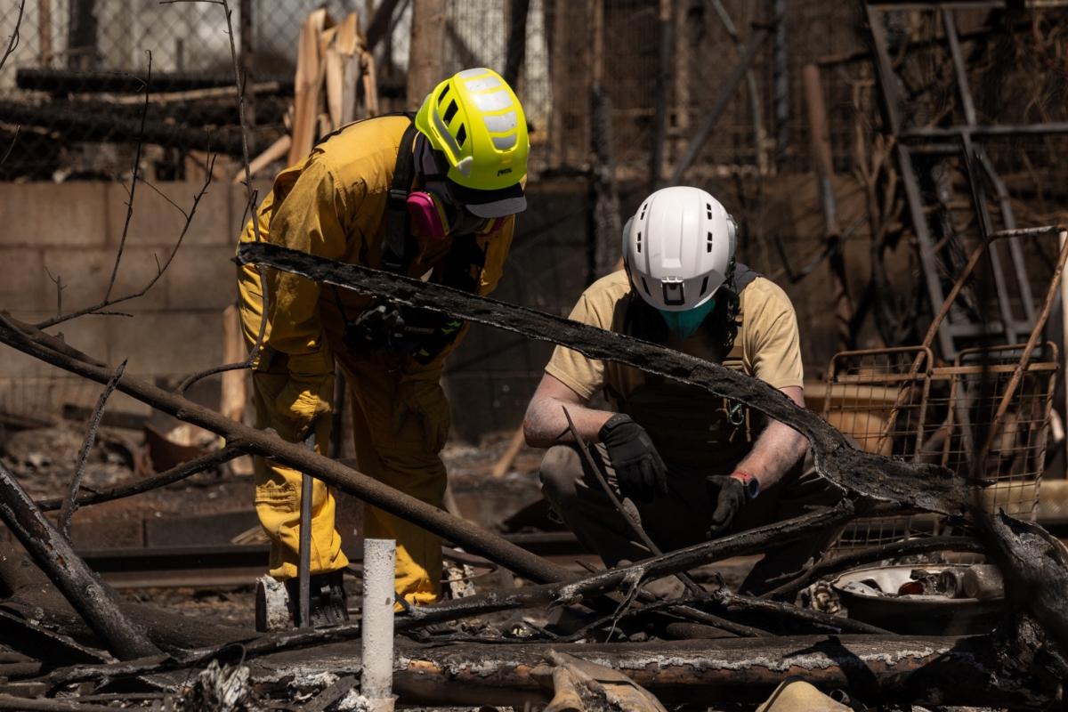 Search and recovery team members check charred buildings and cars in the aftermath of the Maui wildfires in Lahaina, Hawaii, on Aug. 18, 2023. (Yuki Iwamura/AFP via Getty Images)