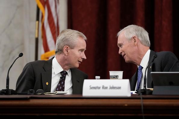 Dr. Peter McCullough (L) confers with Sen. Ron Johnson (R-Wisc.) during a panel discussion on COVID 19, on Jan. 24, 2022. (Drew Angerer/Getty Images)