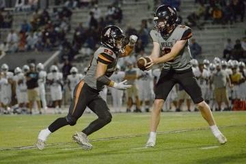 High school football player Brady Edmunds (8) is handing the ball to senior running back Tyler Young (23) at Huntington Beach’s 34–21 victory over Mayfair in Huntington Beach, Calif., on Aug. 18, 2023. (Jeremy Westerbeck/JPWest Media)