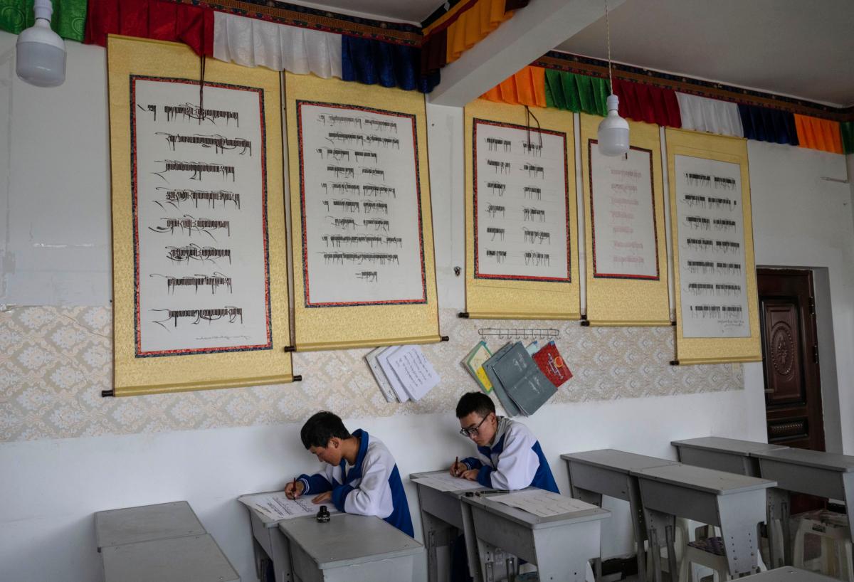 Tibetan students from the Second Senior High School write in Tibetan calligraphy in a class during a government-organized visit in Shannan, Tibet, China, on June 18, 2023. (Kevin Frayer/Getty Images)