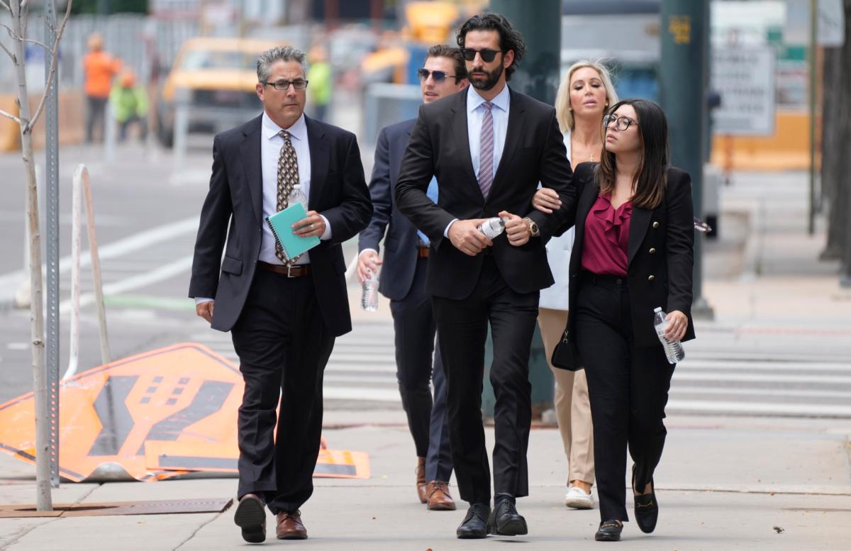 A defense investigator (L) for Pittsburgh dentist Lawrence "Larry" Rudolph heads into federal court with the dentist's children, (front C and back R), for the afternoon session of the trial in Denver on July 13, 2022. (David Zalubowski/AP Photo)