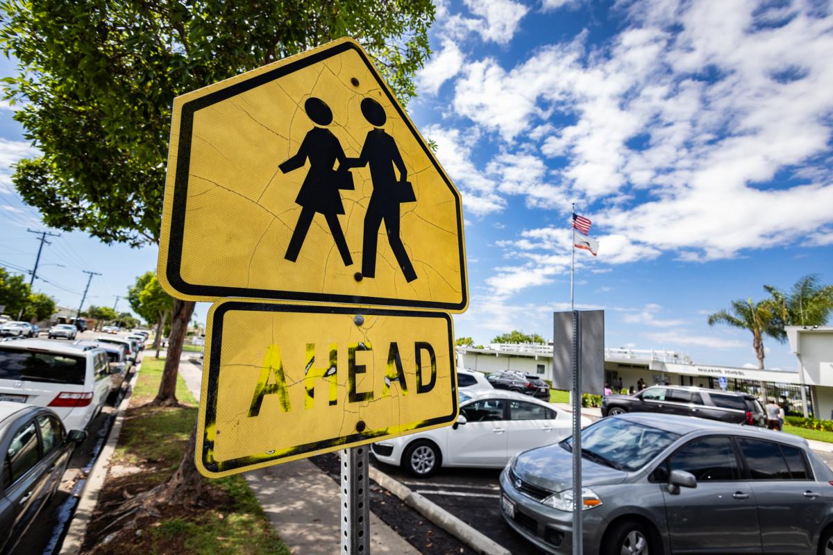 A pedestrian sign outside of an elementary school in Costa Mesa, Calif., on Aug. 21, 2023. (John Fredricks/The Epoch Times)