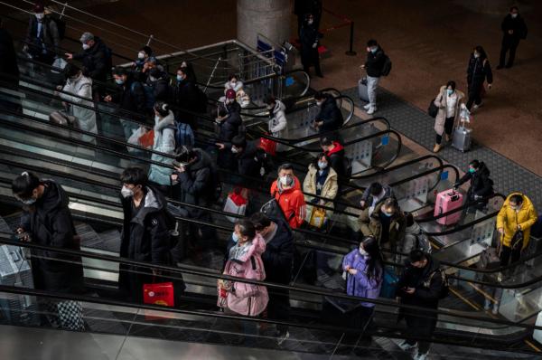 Travelers use an escalator as they arrive to board high-speed trains on their way home for the Chinese Lunar New Year and Spring Festival at Beijing West Station in China on Jan. 20, 2023. (Kevin Frayer/Getty Images)