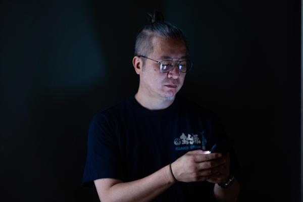 Director Amos Wong said that his life relies very much on the mobile phone, and his phone data show that his average daily duration for using the phone is six to eight hours, doubling that of an average Hongkonger, according to certain surveys. (Benson Lau/The Epoch Times)