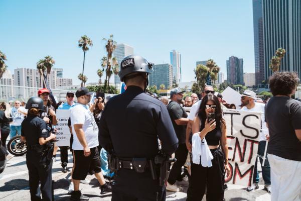 Police officers monitor the situation at a rally attended by about 200 parental rights advocates in downtown Los Angeles to protest secret gender transitions in California public schools, on Aug. 22, 2023. (Courtesy of Hasmik Bezirdshyan)