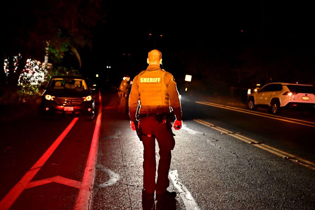 A sheriff's deputy stands in the road after a shooting at "Cook's Corner" bar in Trabuco Canyon, Calif., on Aug. 23, 2023. (Frederic J. Brown/AFP via Getty Images)