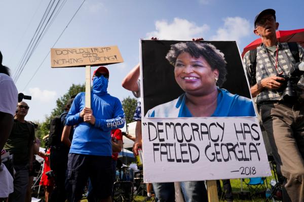 Protestors hold banners at the Fulton County Jail in Atlanta, Ga., on Aug. 24, 2023. (Madalina Vasiliu/The Epoch Times)
