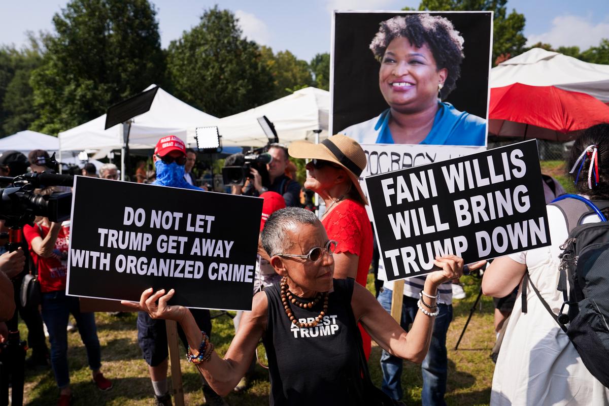 Protestors hold banners at the Fulton County Jail in Atlanta, Ga., on Aug. 24, 2023. (Madalina Vasiliu/The Epoch Times)
