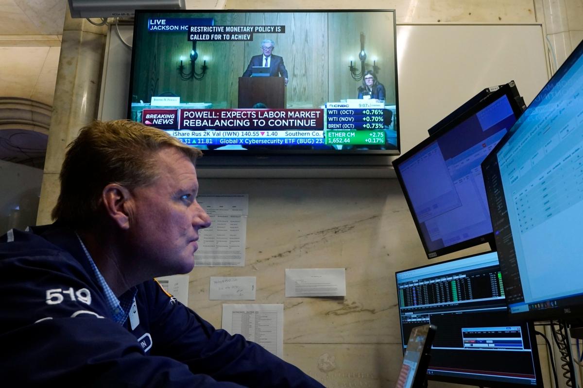  Trader John Bowers works on the floor of the New York Stock Exchange on Aug. 25, 2023, as Federal Reserve Chair Jerome Powell's speech is being broadcast. (Richard Drew/AP Photo)