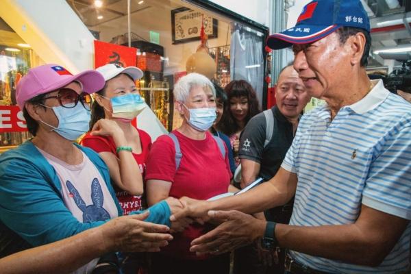 Taiwan's independent presidential candidate and Foxconn founder Terry Gou (right) greets supporters while campaigning at a traditional market in Taipei on Aug. 11, 2023. (Sam Yeh/AFP via Getty Images)