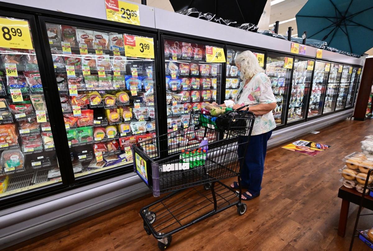 A woman checks items from the refrigerated section while grocery shopping at a supermarket in Alhambra, Calif., on July 13, 2022. (Frederic J. Brown/AFP via Getty Images)